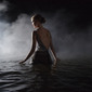 Women in dress appears through mist