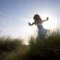 Young girl running in sea grass