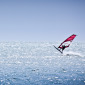 Red windsurfer against the big blue