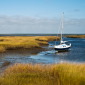 Sailboat anchored in salt marsh.
